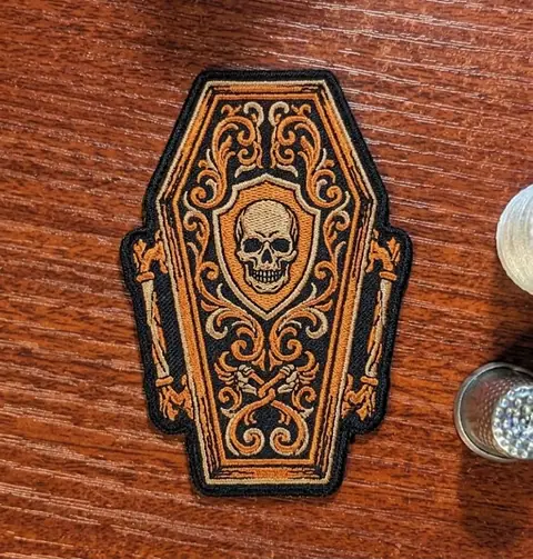 Coffin-shaped Halloween patch with a skull design